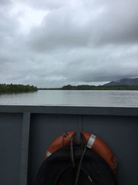 Low section of person on water against sky