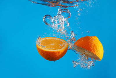 Close-up of lemon slice in water against blue background