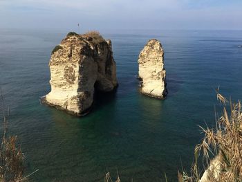 Rock formation in sea against sky