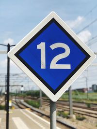 Close-up of road sign against blue sky