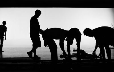 Silhouette people standing against sky