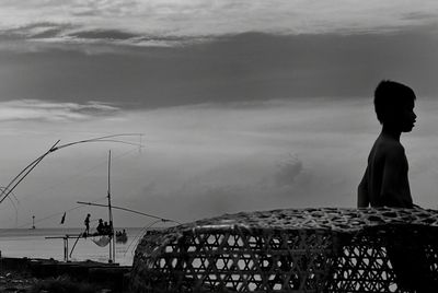 Silhouette of woman against cloudy sky