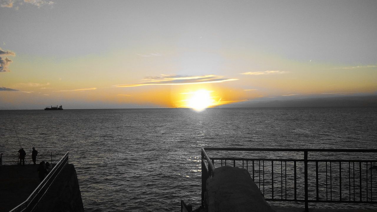 sunset, sea, water, horizon over water, sun, scenics, tranquil scene, sky, tranquility, beauty in nature, nature, pier, idyllic, railing, orange color, sunlight, silhouette, sunbeam, cloud - sky, rippled