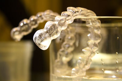 Close-up of dentures in glass container on table