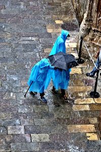 View of man with blue umbrella on wall