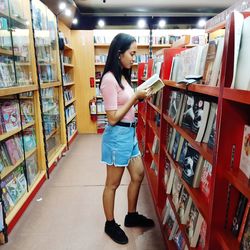 Side view of young woman standing in store