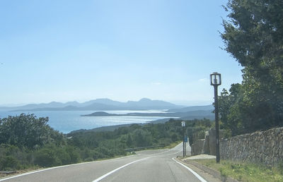 Road leading towards mountains against sky