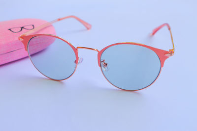 Close-up of sunglasses on table against blue background