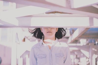 Young woman standing by built structure