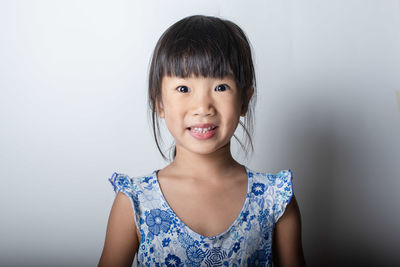 Portrait of smiling girl against white background