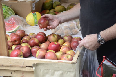 Midsection of man preparing fruits for sale in market