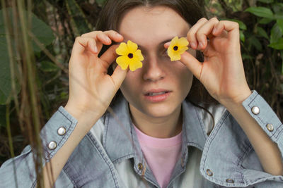 Midsection of woman holding yellow flower