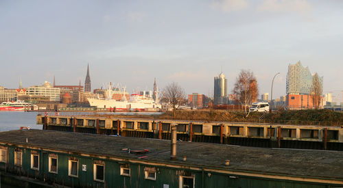 Buildings in city against cloudy sky