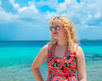 Low angle view of young woman against sea against sky