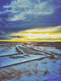 Scenic view of snow covered landscape against cloudy sky