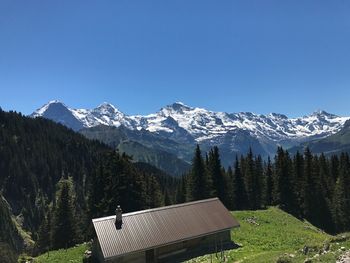 Scenic view of snowcapped mountains against clear blue sky