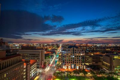 High angle view of illuminated street amidst buildings at night