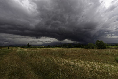 Scenic view of field against cloudy sky