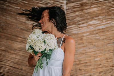 Midsection of woman holding flower bouquet