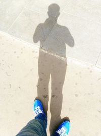 Low section of man standing on tiled floor