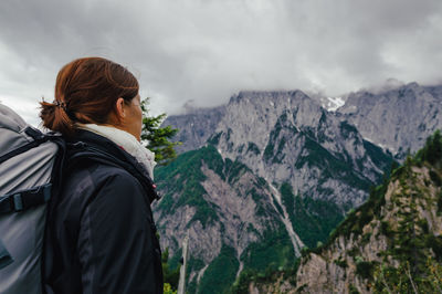 Rear view of woman standing on mountain against sky