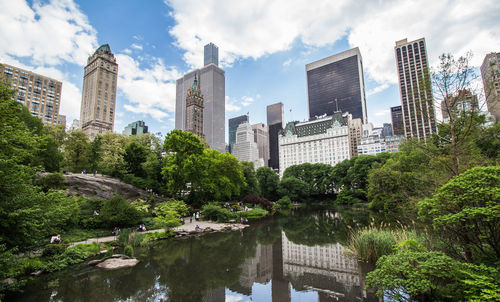 Panoramic view of lake and buildings against sky in city