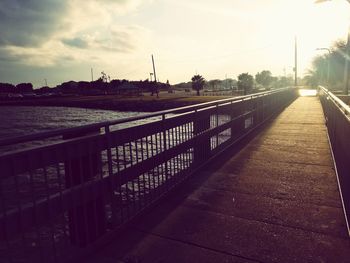 Road by river in city against sky