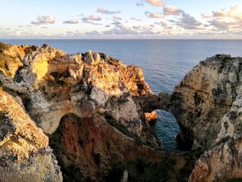 Rock formations by sea against sky