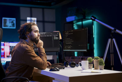 Side view of man using mobile phone in office