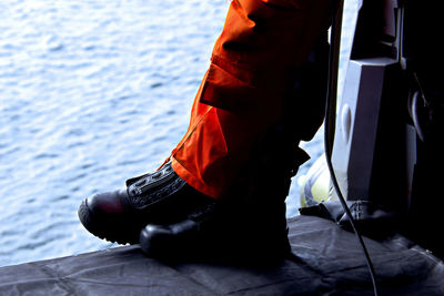 Low section view of person standing on boat in sea 