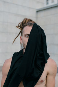 Close-up of young man covering face with textile