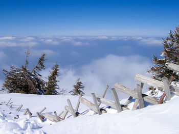 Snow covered landscape against blue sky