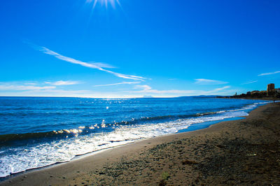 Scenic view of beach against blue sky