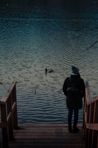 Rear view of men on water at shore