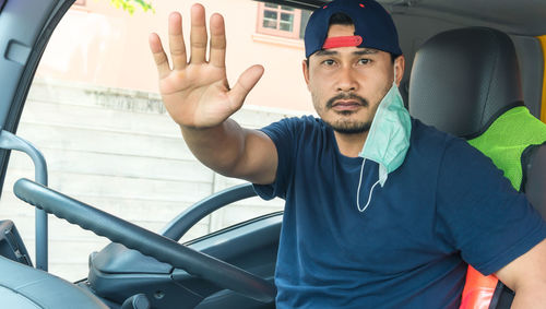 Portrait of young man sitting in car