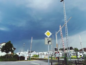 Low angle view of cranes on road against sky