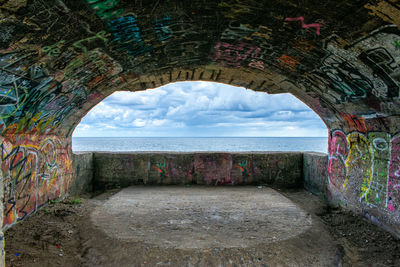 Empty road by sea against sky