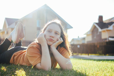 Girl looking away while lying on grass