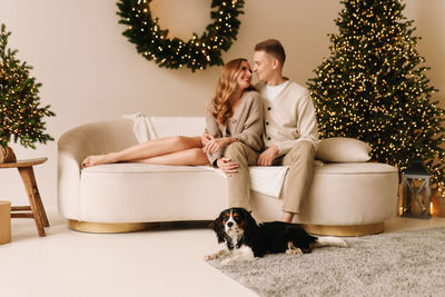 A couple in love hugging and relaxing on a christmas holiday in the decorated interior of the house
