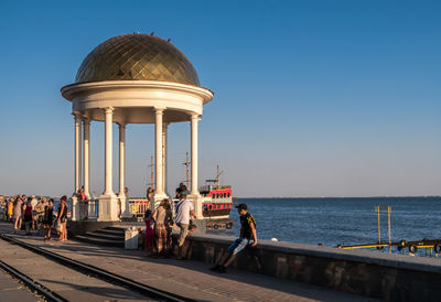 People at sea against clear blue sky