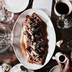 Woman holding jug with chocolate sauce for waffles