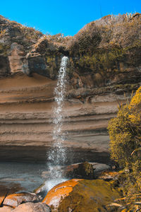 Scenic view of waterfall against sky