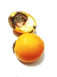 Close-up of orange fruit against white background