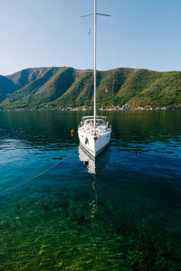 Sailboats moored on sea against sky