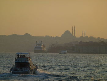 Ship on sea and hagia sofia against sky during sunset