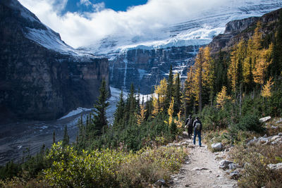 Rear view of people walking on mountain during winter