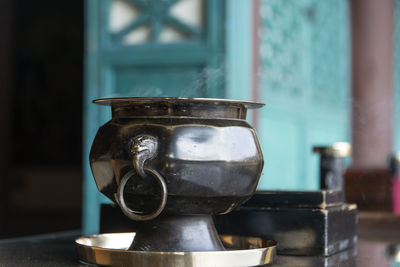 Close-up of container on table with smoke at temple