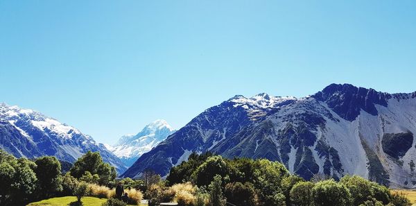 Scenic view of snowcapped mountains against clear blue sky