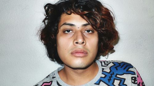 Portrait of young man against wall