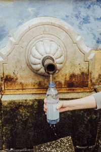 Woman filling plastic bottle with spring water